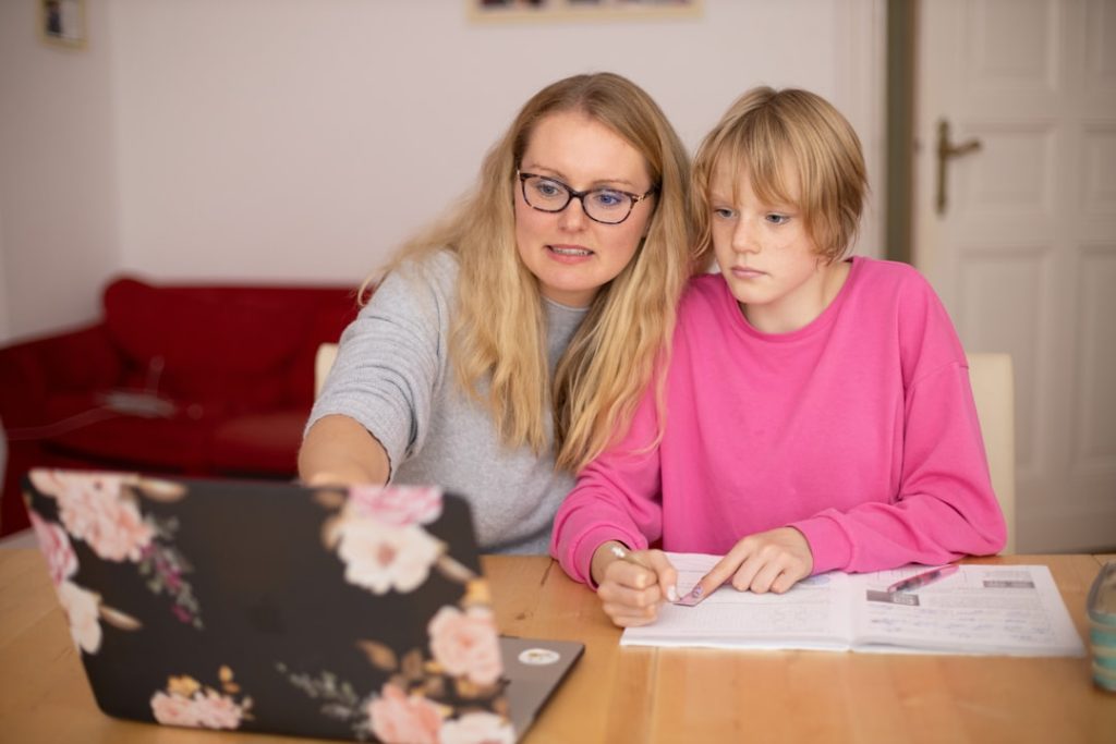 Mother and daugther learning together via laptop.